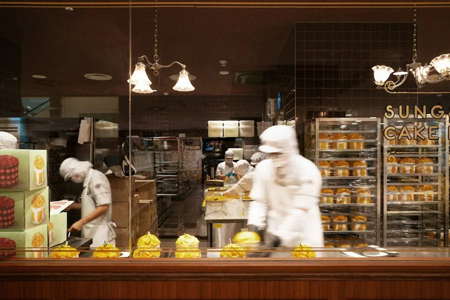 Bakers preparing pastries in a busy production kitchen