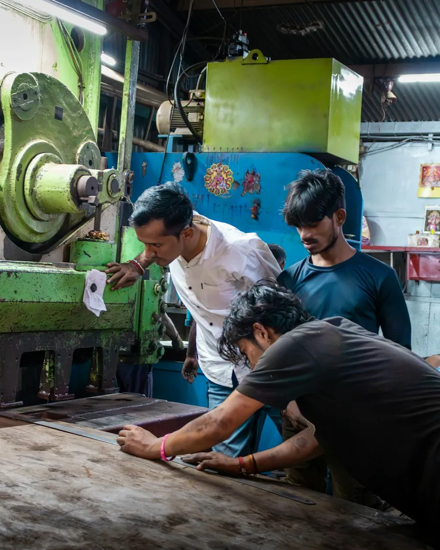 Workers setting up a large machine on a small manufacturing floor